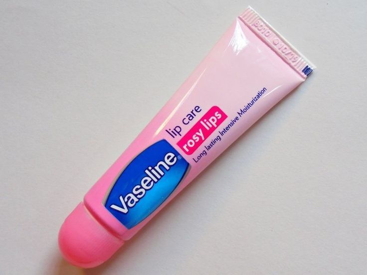 Chirs's UK Vaseline Lip Balm tin open on pink fabric