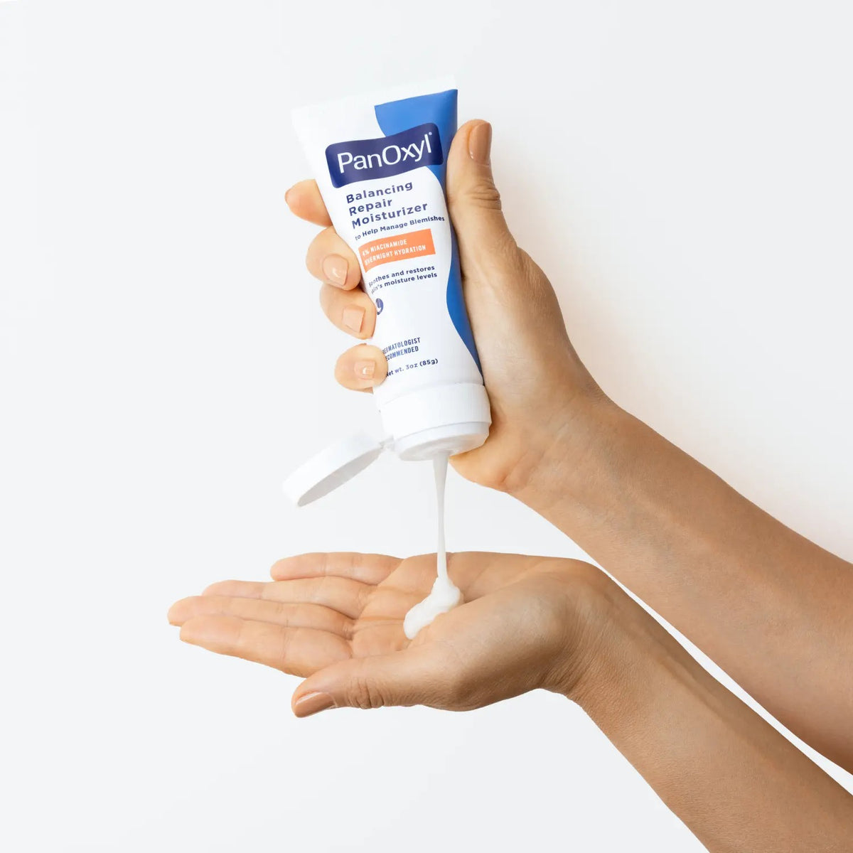 PanOxyl PM Balancing Repair Moisturizer with Niacinamide 85g – hand squeezing tube lifestyle shot